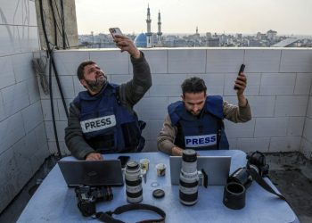 Palestinian journalists attempt to connect to the internet using their phones in Rafah on the southern Gaza Strip on December 27, 2023. ©AFP