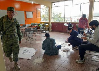 Electoral workers examine ballots while counting votes at a polling station in Cuenca, Ecuador, on October 15, 2023. ©AFP