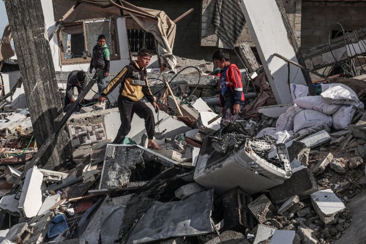 Palestinian boys walk through the rubble of a house destroyed by Israeli bombardment in Rafah, the southern Gaza Strip / ©AFP