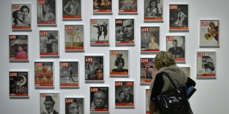 A woman looks at LIFE magazine copies as part of the show "Sorprendeme!", a retrospective of Philippe Halsman at CaixaForumin Madrid, November 30, 2016. ©AFP