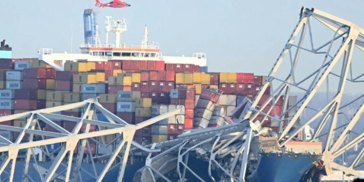 The steel frame of the Francis Scott Key Bridge sit on top of a container ship after the bridge collapsed in Baltimore, Maryland, on March 26, 2024. ©AFP