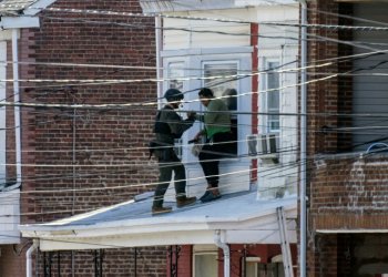 Police evacuate residents from a home in Trenton, New Jersey, where a suspect was believed to be holed up after allegedly killing three family members earlier in the day . ©AFP