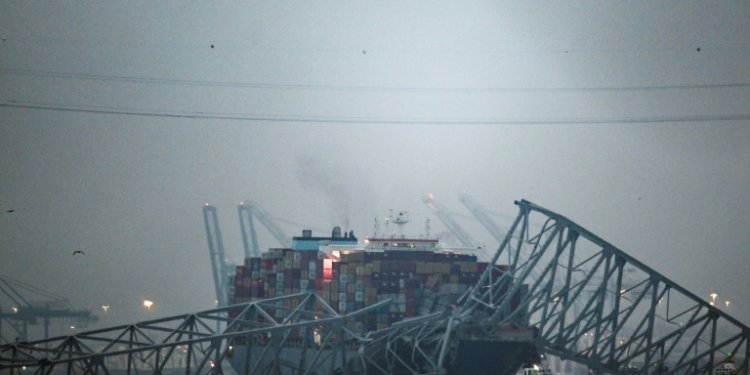 The collapsed Francis Scott Key Bridge lies on top of  the container ship Dali in Baltimore, Maryland. ©AFP