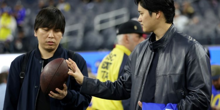 Baseball star Shohei Ohtani talks with his interpreter Ippei Mizuhara before an NFL football game between the New Orleans Saints and the Los Angeles Rams at SoFi Stadium. ©AFP