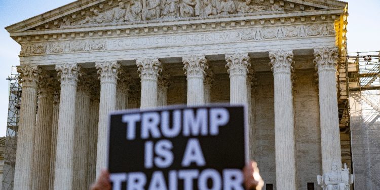 Anti-Trump demonstrators protest outside the US Supreme Court as the court considers whether former US President Donald Trump is eligible to run for president in the 2024 election in Washington, DC, on February 8, 2024 / ©AFP