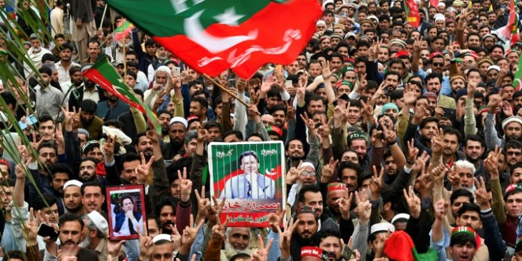 Pakistan Tehreek-e-Insaf (PTI) party supporters hold portraits of former prime minister Imran Khan in a March 2024 protest in Peshawar against alleged rigging of the election against him. ©AFP