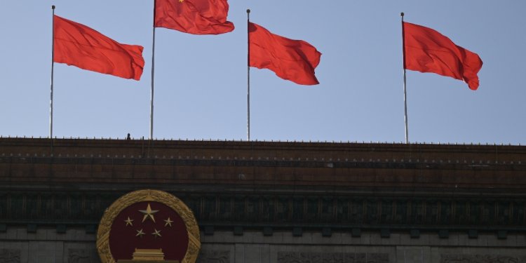 Chinese flags flutter atop the Great Hall of the People in Beijing on March 3, 2024, ahead of the country's annual legislative meetings known as the Two Sessions. / ©AFP