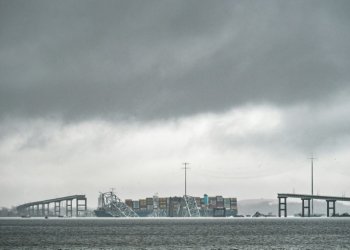 The Dali, a Singaporean-flagged cargo vessel that spans the size of almost three football fields, remains stuck under debris from the Francis Scott Key Bridge on March 27, 2024 after the ship crashed into the bridge in Baltimore, Maryland. ©AFP