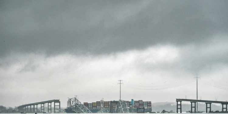 The Dali, a Singaporean-flagged cargo vessel that spans the size of almost three football fields, remains stuck under debris from the Francis Scott Key Bridge on March 27, 2024 after the ship crashed into the bridge in Baltimore, Maryland. ©AFP