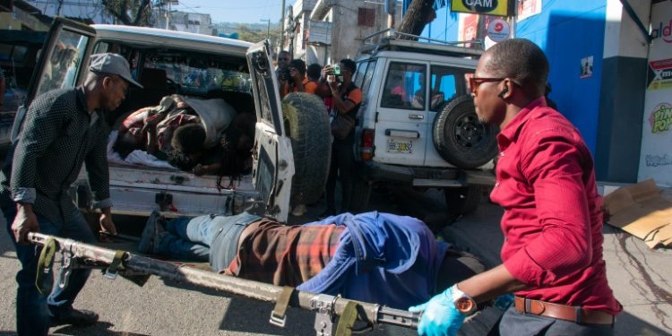 Paramedics carry the body of a person killed by gang members in Petionville, Port-au-Prince, Haiti. ©AFP