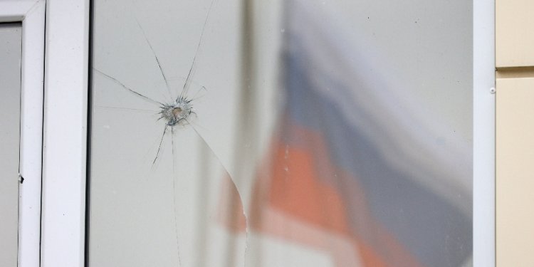 A Russian flag reflected in a damaged window after an aerial attack near Belgorod on Tuesday / ©AFP