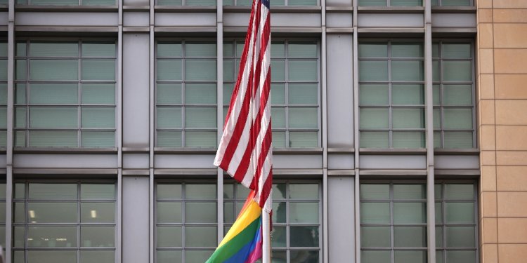 The rainbow flag flies under the US flag at the entrance to the US embassy in Moscow in June 2021 / ©AFP