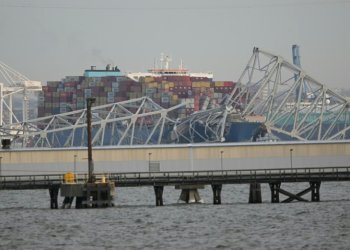 The steel frame of the Francis Scott Key Bridge sits on top of a container ship after the bridge collapsed in Baltimore, Maryland, on March 26, 2024. ©AFP