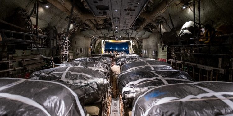 Humanitarian aid pallets rigged with parachutes for an airdrop over Gaza are loaded and prepared for takeoff onboard a US military cargo plane / ©AFP