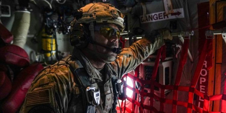 A member of the US Air Force 26th Expeditionary Rescue Squadron aboard an HC-130J aircraft prepares to airdrop humanitarian aid supplied by Jordan over the Gaza Strip. ©AFP