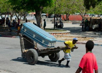 A man transports a coffin through the streets of the Haitian capital Port-au-Prince on March 22, 2024. ©AFP