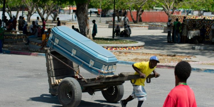 A man transports a coffin through the streets of the Haitian capital Port-au-Prince on March 22, 2024. ©AFP