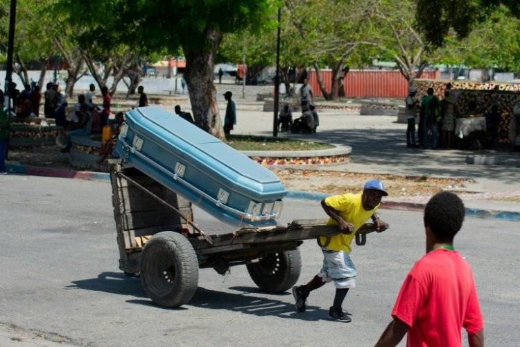 A man transports a coffin through the streets of the Haitian capital Port-au-Prince on March 22, 2024. ©AFP