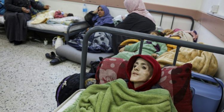 Ten-year-old Palestinian boy, Yazan al-Kafarneh, displaced from Beit Hanun and suffering from a pre-existing condition, lies on a hospital bed at Al-Awda clinic in Rafah; he died on March 4 severe malnourishment and insufficient healthcare. ©AFP