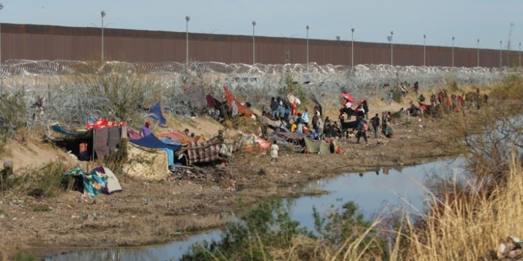 Migrants on the Mexican side of the border wait to cross into the United States at a point near El Paso, Texas, on March 19, 2024. ©AFP