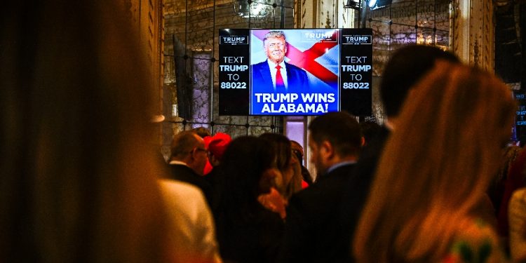 Supporters of former US President and 2024 presidential hopeful Donald Trump watch a screen announcing Trump wins Alabama as they attend a Super Tuesday election night watch party at Mar-a-Lago Club in Palm Beach, Florida, on March 5, 2024 / ©AFP