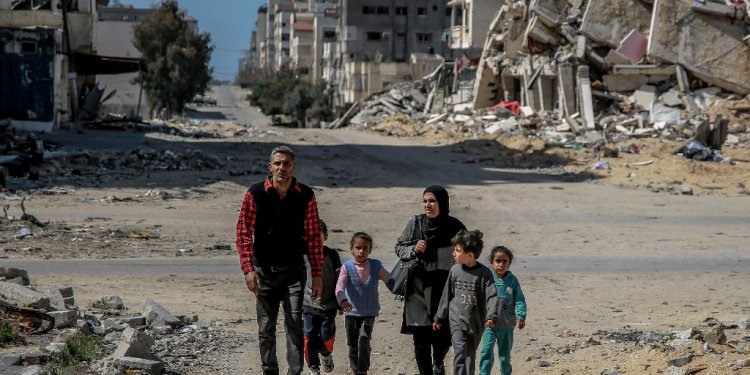 A Palestinian family walks through the destruction of Gaza City, in the territory's north where aid workers say the humanitarian situation is particularly actue / ©AFP