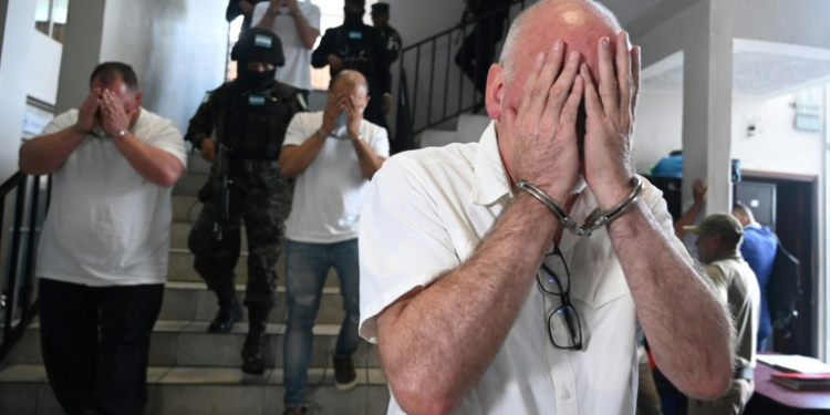 US citizens Harold Joseph Green (R), William James Murdock (L) and Gary Lee Johnston (Ctr), cover their faces near a court in Tegucigalpa. ©AFP