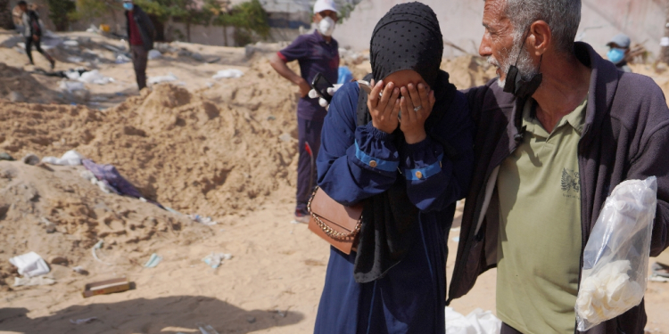 Palestinians react after the body of a relative was found buried at the Nasser hospital in southern Gaza / ©AFP