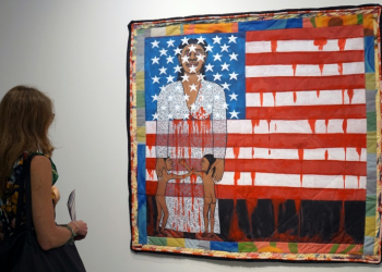 A visitor watches the work of US artist Faith Ringgold, "The Flag is Bleeding #2" (1997) in December 1997 ahead of the opening of the Art Basel international fair that takes place annually in Miami Beach. ©AFP