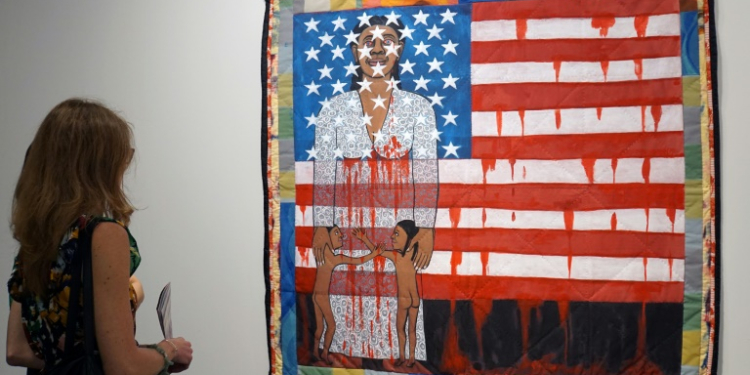 A visitor watches the work of US artist Faith Ringgold, "The Flag is Bleeding #2" (1997) in December 1997 ahead of the opening of the Art Basel international fair that takes place annually in Miami Beach. ©AFP