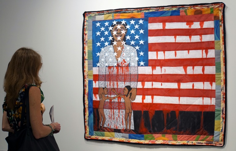 A visitor watches the work of US artist Faith Ringgold, "The Flag is Bleeding #2" (1997) in December 1997 ahead of the opening of the Art Basel international fair that takes place annually in Miami Beach. ©AFP