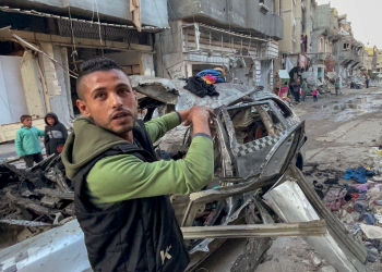 A man gestures in front of the car in which three sons of Hamas leader Ismail Haniyeh were killed  / ©AFP