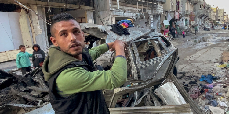 A man gestures in front of the car in which three sons of Hamas leader Ismail Haniyeh were killed  / ©AFP