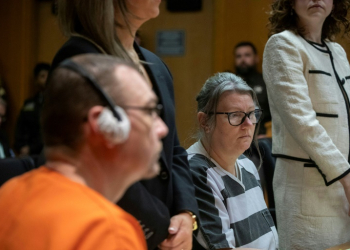 James Crumbley (L in orange) and his wife, Jennifer Crumbley (R in black-and-white stripes) were sentenced to 10-15 years in prison. ©AFP