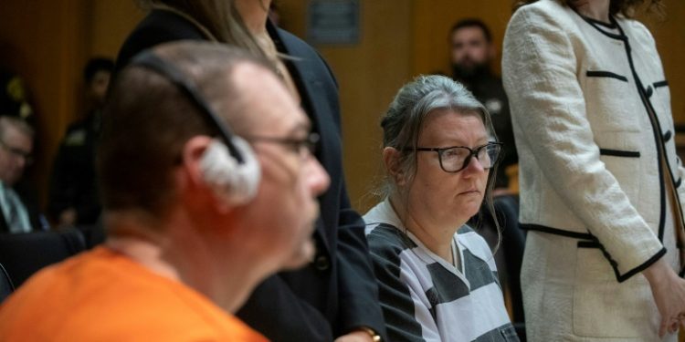 James Crumbley (L in orange) and his wife, Jennifer Crumbley (R in black-and-white stripes) were sentenced to 10-15 years in prison. ©AFP