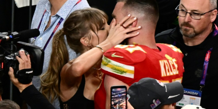 Taylor Swift, shown here kissing Travis Kelce at the 2024 Super Bowl, was spotted at Coachella similarly canoodling with her NFL boyfriend during the set of Bleachers, which is fronted by her producer. ©AFP