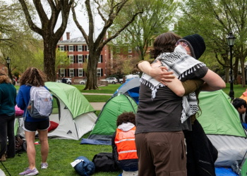 Pro-Palestinian students embrace each other as they take down their encampment after reaching a deal with Brown University in Providence, Rhode Island. ©AFP