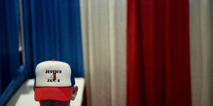 A man at a Republican event in Maryland on February 22, 2024, wears a cap to show support for people sentenced to jail for their roles in the January 6, 2021, occupation of the US Capitol  / ©AFP