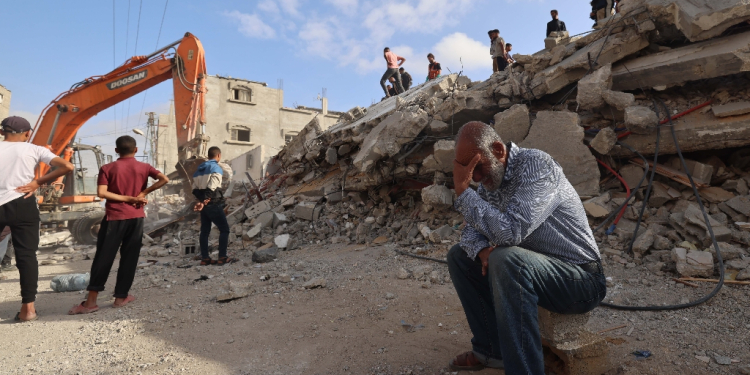 A Palestinian man waits for news of his daughter as rescue workers search for survivors after an overnight Israeli bombing in Rafah, the southern Gaza Strip / ©AFP