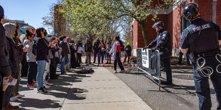 Pro-Palestinian protesters stand in front of a police barricade after police raided an encampment at Northeastern University in Boston, Massachusetts, on April 27, 2024 / ©AFP