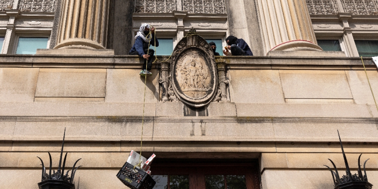 Pro-Palestinian student protestors pull a crate with pizza boxes inside from a balcony in Hamilton Hall at Columbia University in New York City on April 30, 2024 / ©AFP