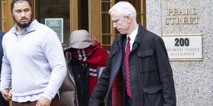 British billionaire and Tottenham Hotspur mogul Joe Lewis hides behind a scarf as he leaves federal court in New York after sentencing in an insider trading case on April 4, 2024 . ©AFP