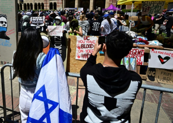 Pro-Israel (front) and pro-Palestinian students face off at an encampment on the campus of the University of California Los Angeles . ©AFP