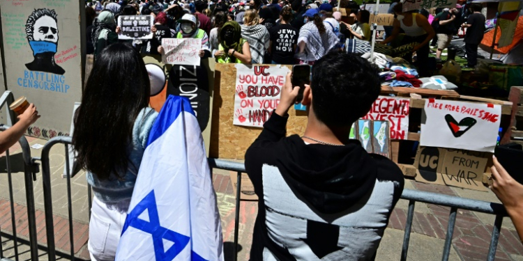 Pro-Israel (front) and pro-Palestinian students face off at an encampment on the campus of the University of California Los Angeles . ©AFP