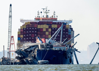 A section of the Francis Scott Key Bridge rests in the water next to the Dali container ship in Baltimore on May 13, 2024, after crews conducted a controlled demolition. ©AFP