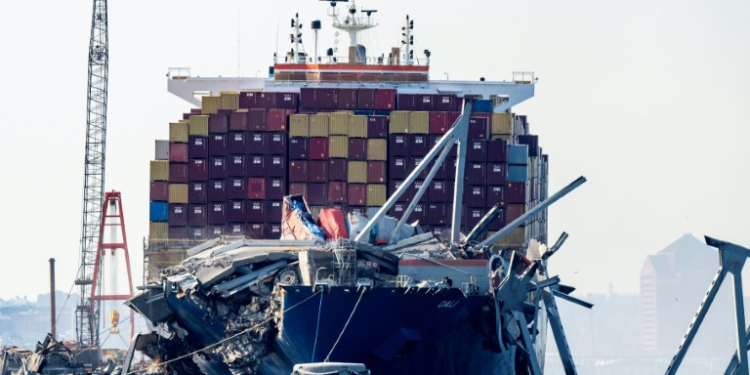 A section of the Francis Scott Key Bridge rests in the water next to the Dali container ship in Baltimore on May 13, 2024, after crews conducted a controlled demolition. ©AFP