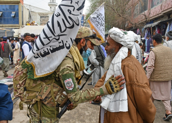 A Taliban security personnel greets a Muslim devotee after Eid al-Fitr prayers in the city of Pul-e-Khumri in April 2024 / ©AFP