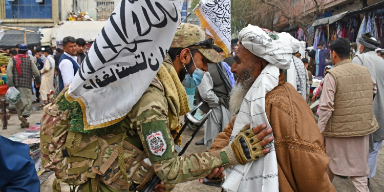 A Taliban security personnel greets a Muslim devotee after Eid al-Fitr prayers in the city of Pul-e-Khumri in April 2024 / ©AFP