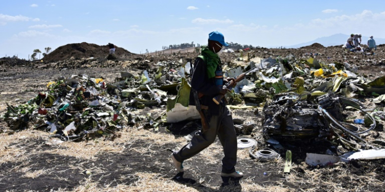 A man walks by a pile of twisted debris at the crash site of an Ethiopian Airways Boeing 737 MAX in March 2019. ©AFP