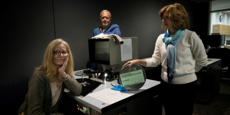 (L-R) Jennifer Taylor-Rossel, Robert Neal Marshall and Patricia Spae look through archive photos and video from World War II -- shot by their ancestors. ©AFP